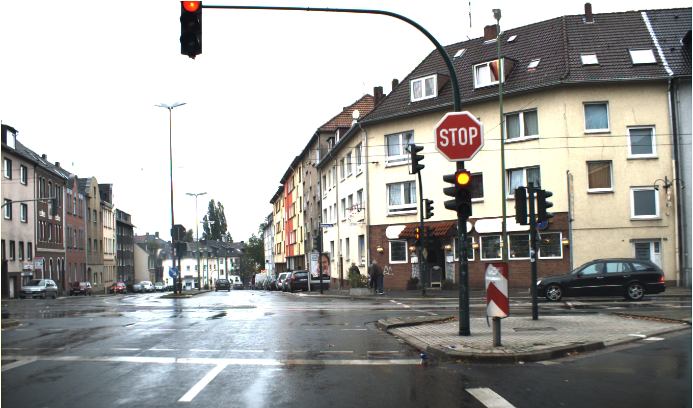 Traffic light intersection with active red light and with stop sign.